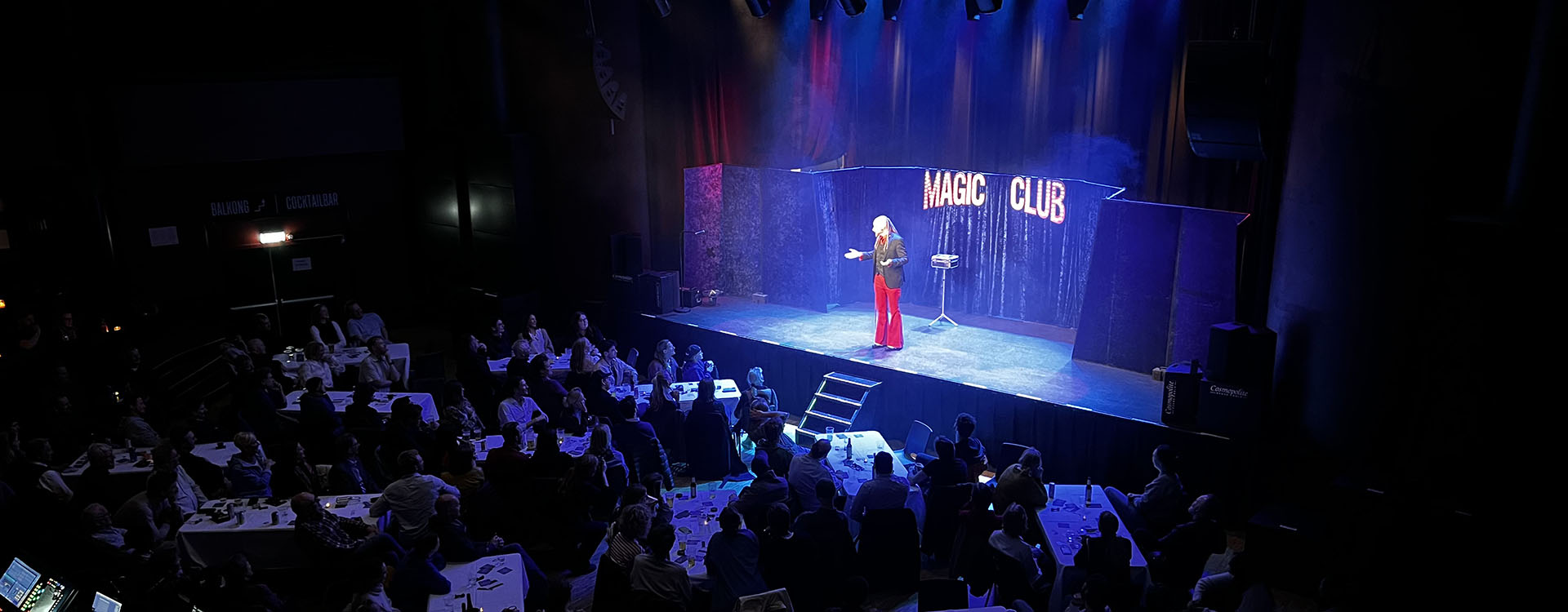 En stor scen där det står "Magic Club" Arkadia kan synas i rött på den övrigt blåtonade bilden.